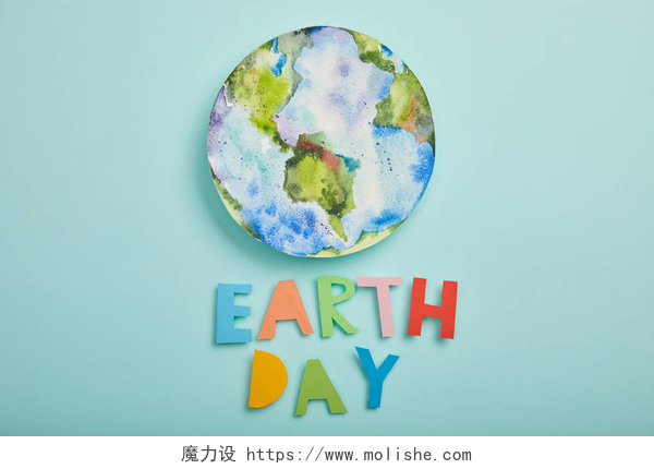 蓝绿色背景上的一个彩色盘子和字母五颜六色的纸质信件和行星图片的顶视图在绿松石背景, 地球天概念